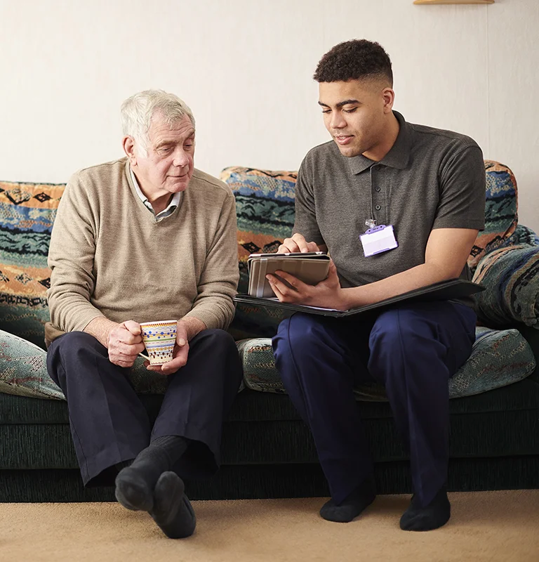 Younger Man Older Man Looking At Tablet