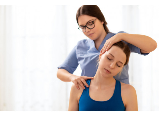 Female Physiotherapist Or A Chiropractor Adjusting Patients Neck. Physiotherapy, Rehabilitation Concept. White Background Front View With Copy Space.