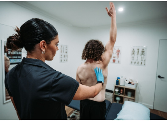 Physiotherapist assessing shoulder movement in a patient with frozen shoulder at Head2Toe Physiotherapy