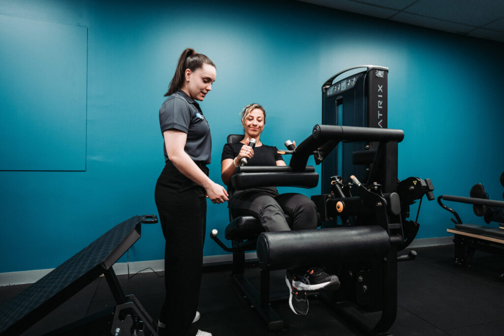 leg extension machine with physiotherapist for sports rehab